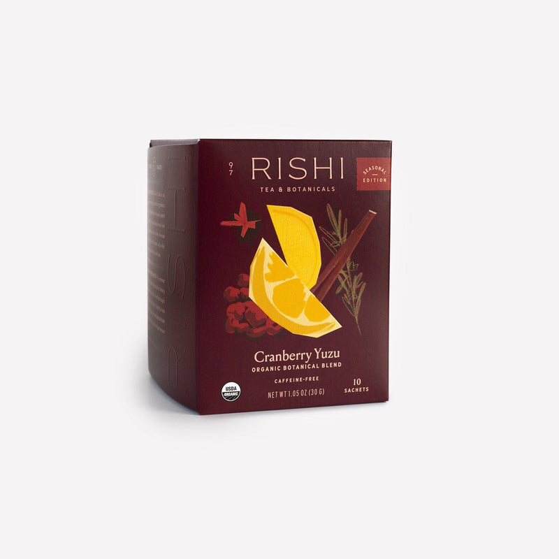 A box of Rishi Tea & Botanicals Cranberry Yuzu organic, caffeine-free botanical blend with hibiscus and schisandra berry, containing 10 sachets and adorned with vibrant fruit and botanical art on the front.